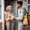 A senior woman receives a meal delivery, highlighting local food assistance for seniors.